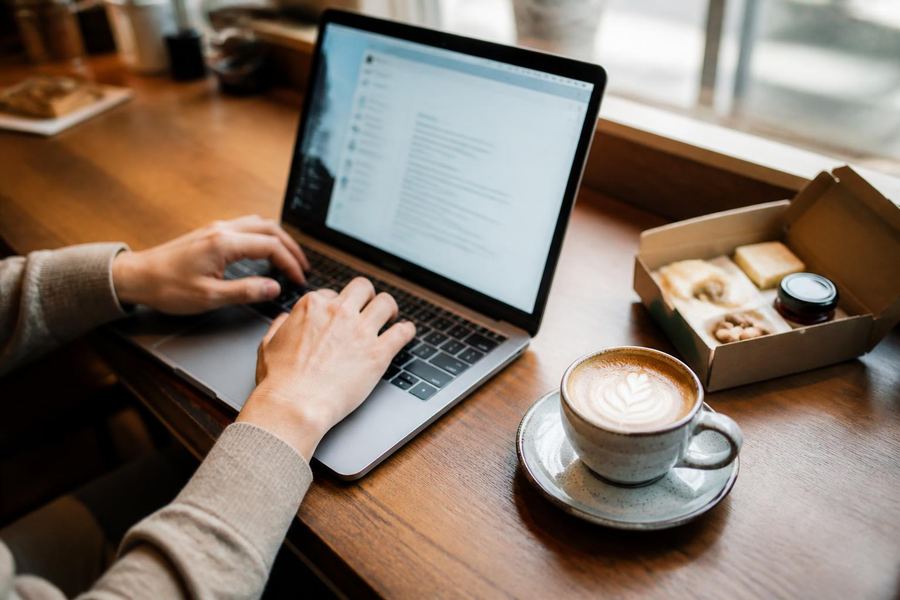 Researching the right buyers on a laptop at a cafe table